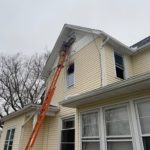 Roof and siding contractor finishing second story siding