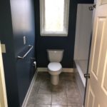Professional remodeling contractors finished blue bathroom with tiled floors
