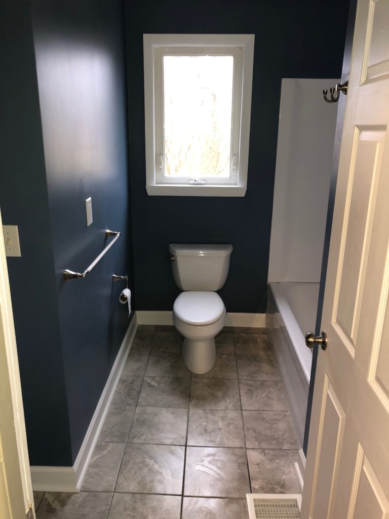 Professional remodeling contractors finished blue bathroom with tiled floors