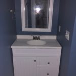 Professional remodeling contractors finished blue bathroom with tiled floors