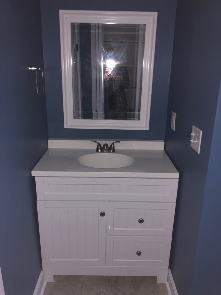 Professional remodeling contractors finished blue bathroom with tiled floors