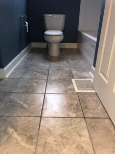 Professional remodeling contractors finished blue bathroom with tiled floors